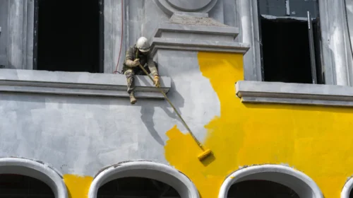 woker painting the office building exterior